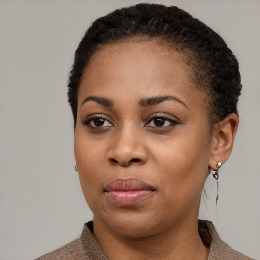 Joyful black young-adult female with short  black hair and brown eyes