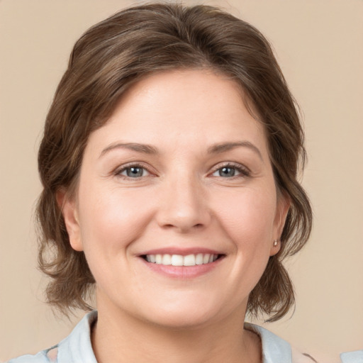 Joyful white young-adult female with medium  brown hair and grey eyes