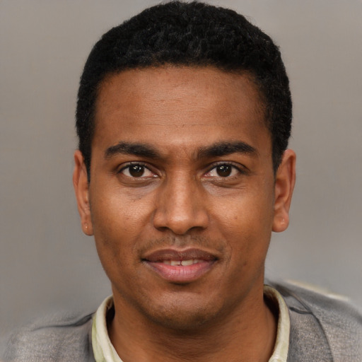 Joyful black young-adult male with short  black hair and brown eyes