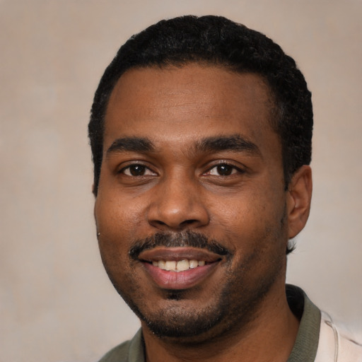 Joyful black young-adult male with short  black hair and brown eyes