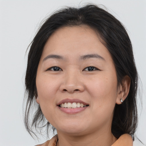 Joyful asian young-adult female with medium  brown hair and brown eyes