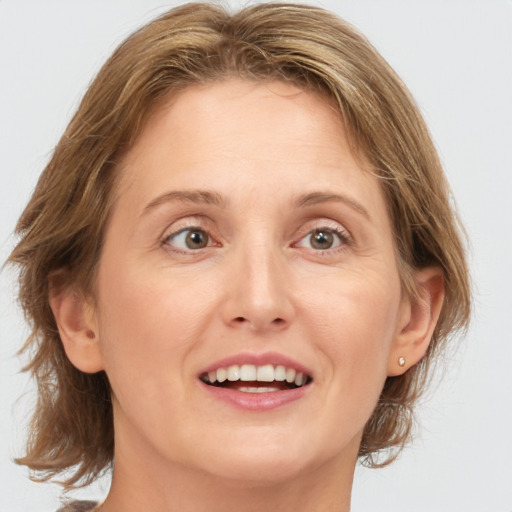 Joyful white adult female with medium  brown hair and grey eyes