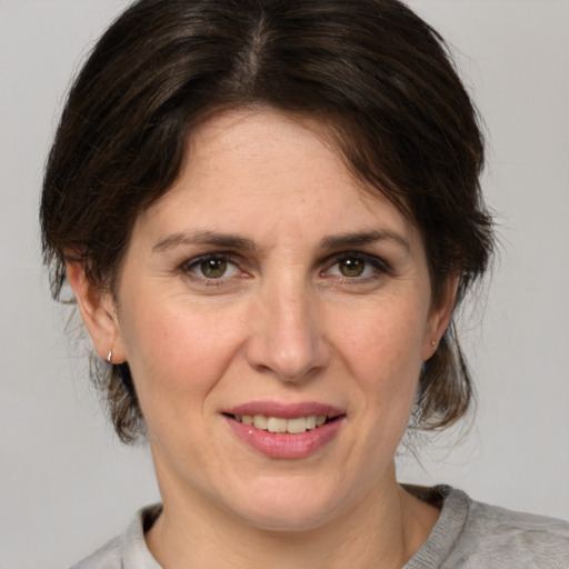 Joyful white adult female with medium  brown hair and grey eyes