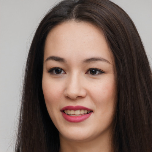 Joyful asian young-adult female with long  brown hair and brown eyes