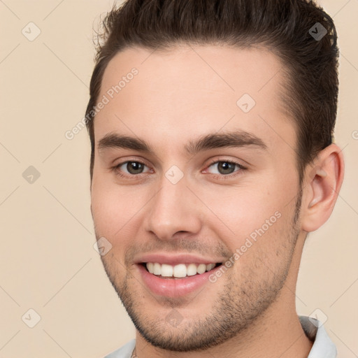 Joyful white young-adult male with short  brown hair and brown eyes