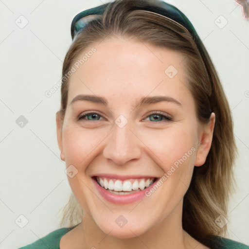 Joyful white young-adult female with long  brown hair and blue eyes