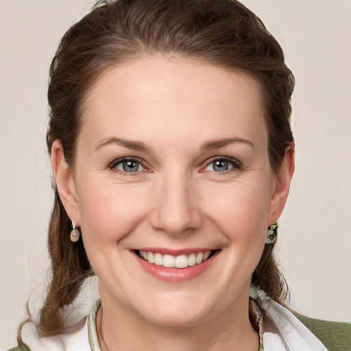 Joyful white young-adult female with medium  brown hair and grey eyes