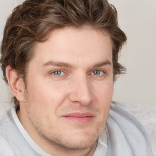 Joyful white young-adult male with short  brown hair and blue eyes