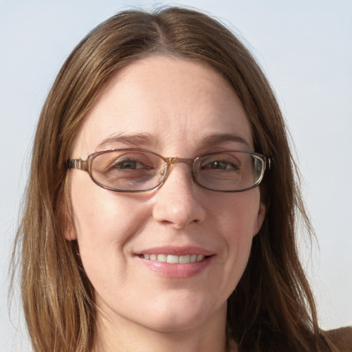 Joyful white adult female with long  brown hair and blue eyes