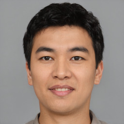 Joyful asian young-adult male with short  black hair and brown eyes