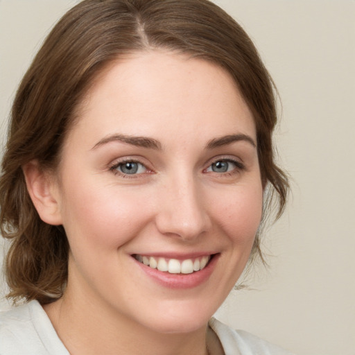 Joyful white young-adult female with medium  brown hair and green eyes