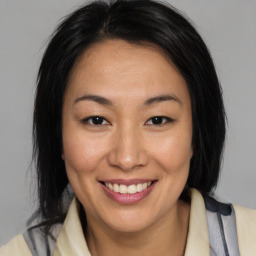 Joyful asian young-adult female with medium  brown hair and brown eyes