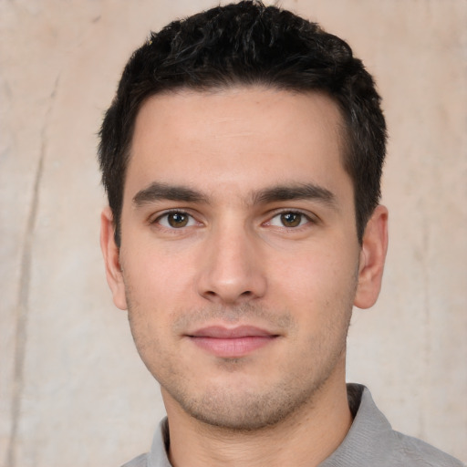 Joyful white young-adult male with short  black hair and brown eyes