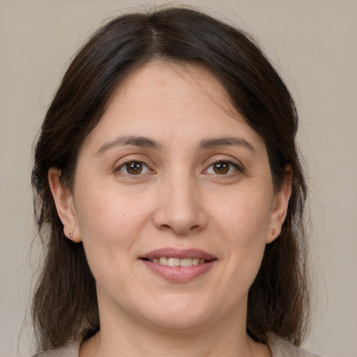 Joyful white adult female with medium  brown hair and brown eyes