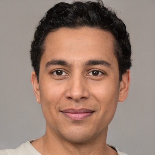 Joyful white young-adult male with short  black hair and brown eyes