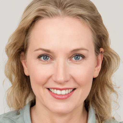 Joyful white young-adult female with medium  brown hair and blue eyes