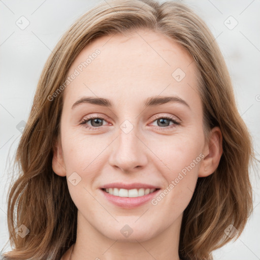 Joyful white young-adult female with long  brown hair and blue eyes