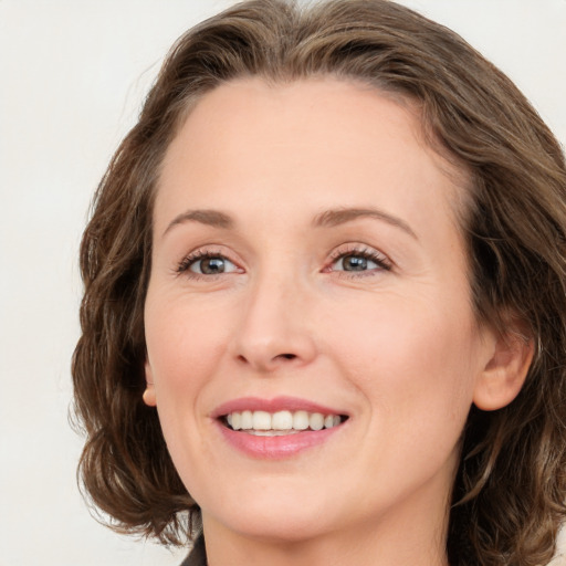 Joyful white young-adult female with medium  brown hair and green eyes