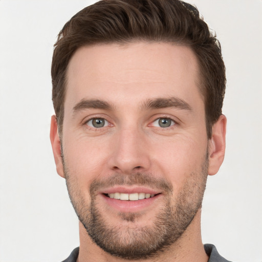 Joyful white young-adult male with short  brown hair and grey eyes