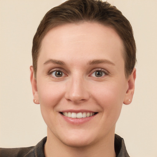 Joyful white young-adult female with short  brown hair and grey eyes