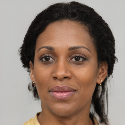 Joyful black adult female with medium  brown hair and brown eyes