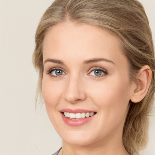 Joyful white young-adult female with medium  brown hair and blue eyes