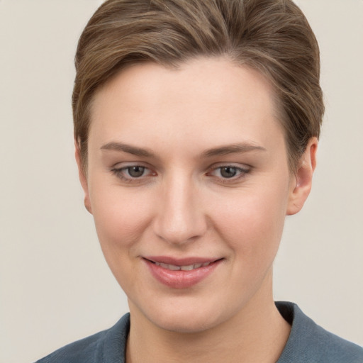 Joyful white young-adult female with short  brown hair and grey eyes