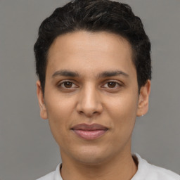 Joyful latino young-adult male with short  brown hair and brown eyes