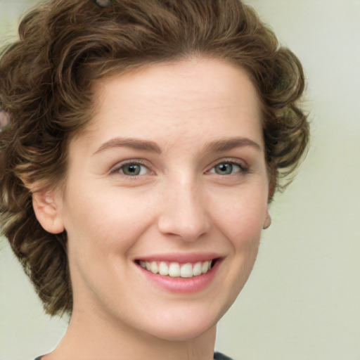 Joyful white young-adult female with medium  brown hair and green eyes