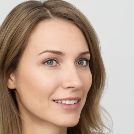 Joyful white young-adult female with long  brown hair and grey eyes