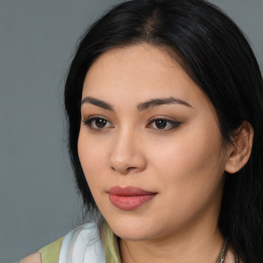 Joyful latino young-adult female with long  black hair and brown eyes