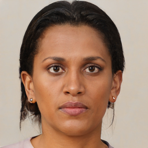 Joyful black young-adult female with medium  brown hair and brown eyes