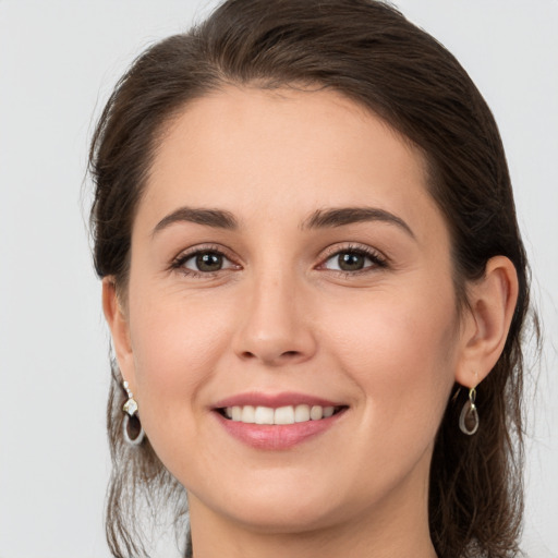 Joyful white young-adult female with medium  brown hair and grey eyes