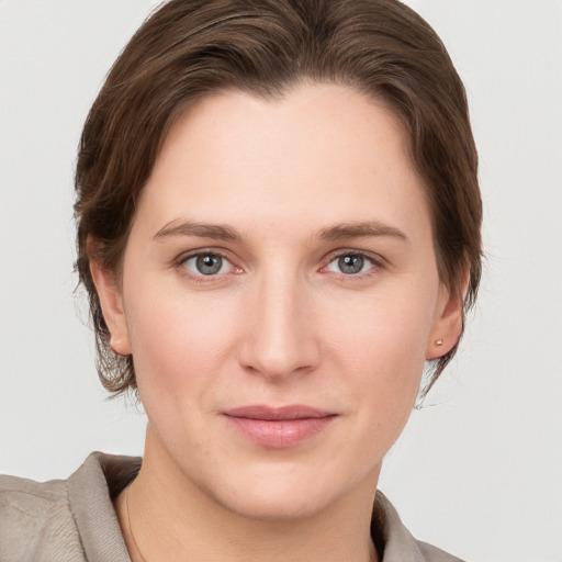 Joyful white young-adult female with medium  brown hair and grey eyes