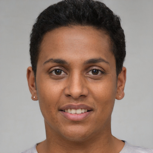 Joyful black young-adult female with short  black hair and brown eyes