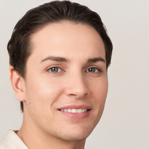 Joyful white young-adult male with short  brown hair and grey eyes