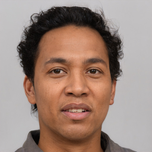 Joyful latino adult male with short  brown hair and brown eyes