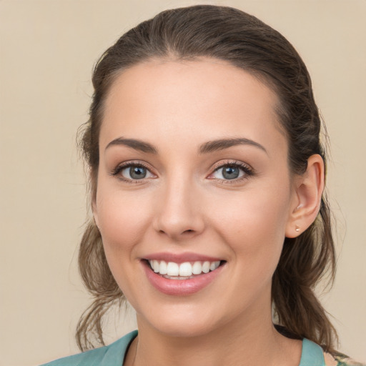 Joyful white young-adult female with medium  brown hair and green eyes