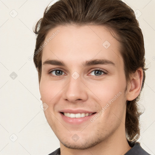 Joyful white young-adult male with short  brown hair and grey eyes