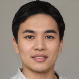 Joyful asian young-adult male with short  black hair and brown eyes