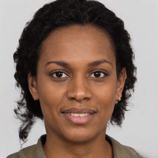 Joyful black young-adult female with medium  brown hair and brown eyes