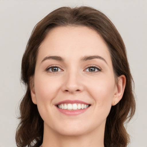 Joyful white young-adult female with medium  brown hair and green eyes