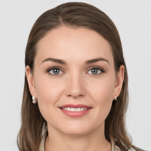 Joyful white young-adult female with medium  brown hair and grey eyes