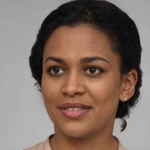 Joyful black young-adult female with short  black hair and brown eyes
