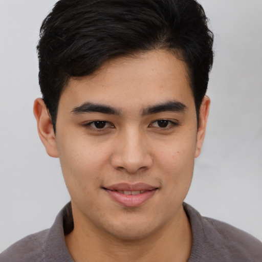 Joyful asian young-adult male with short  brown hair and brown eyes