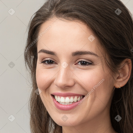 Joyful white young-adult female with long  brown hair and brown eyes