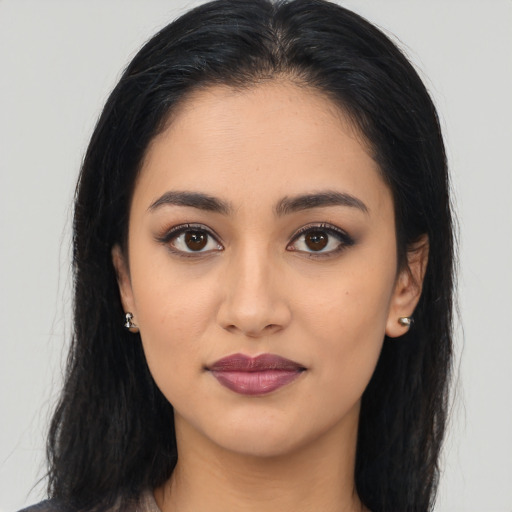 Joyful latino young-adult female with medium  brown hair and brown eyes