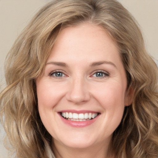 Joyful white young-adult female with medium  brown hair and green eyes