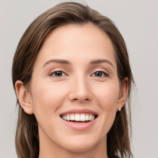 Joyful white young-adult female with long  brown hair and grey eyes