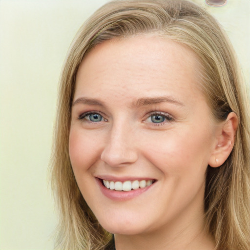 Joyful white young-adult female with long  brown hair and blue eyes